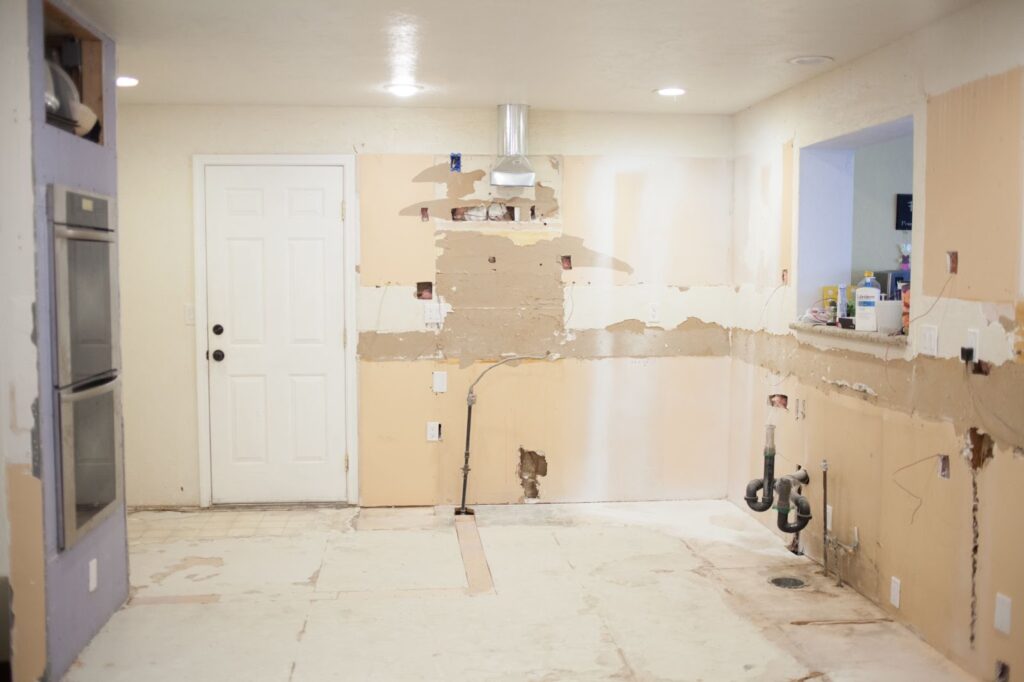 Image of a kitchen with a sink and a refrigerator being demolished by professionals