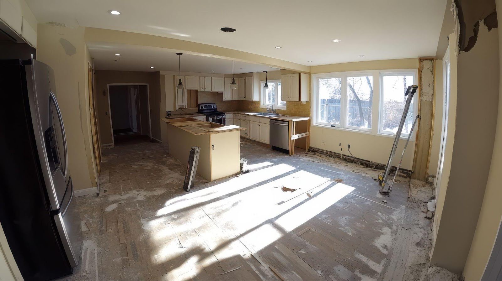 A bright kitchen with a large window and modern refrigerator creating an inviting atmosphere