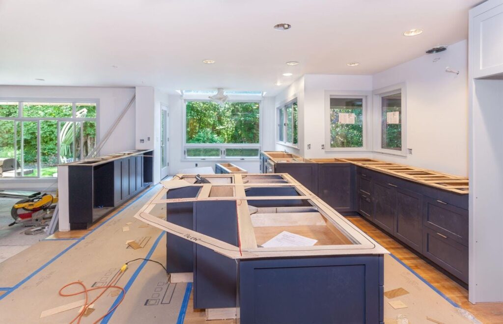 A modern kitchen featuring blue cabinets and warm wood floors, creating a stylish and inviting atmosphere