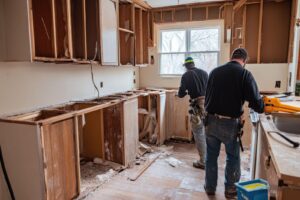 Two men engaged in a kitchen remodel working together to install new countertops and cabinetry