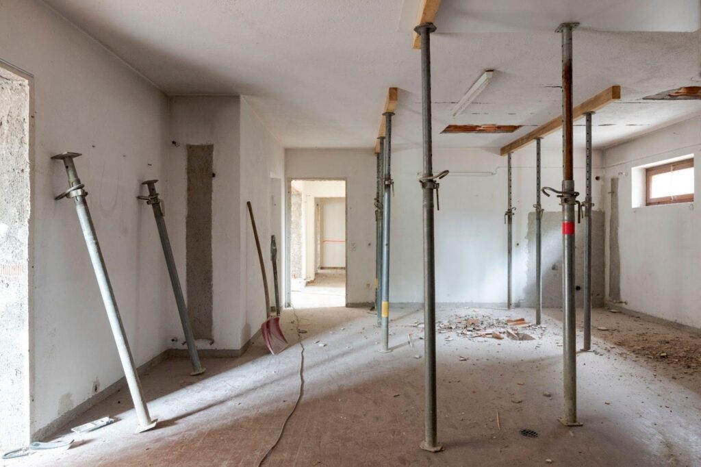 Interior view of a room cluttered with an assortment of construction tools and equipment showcasing an active worksite