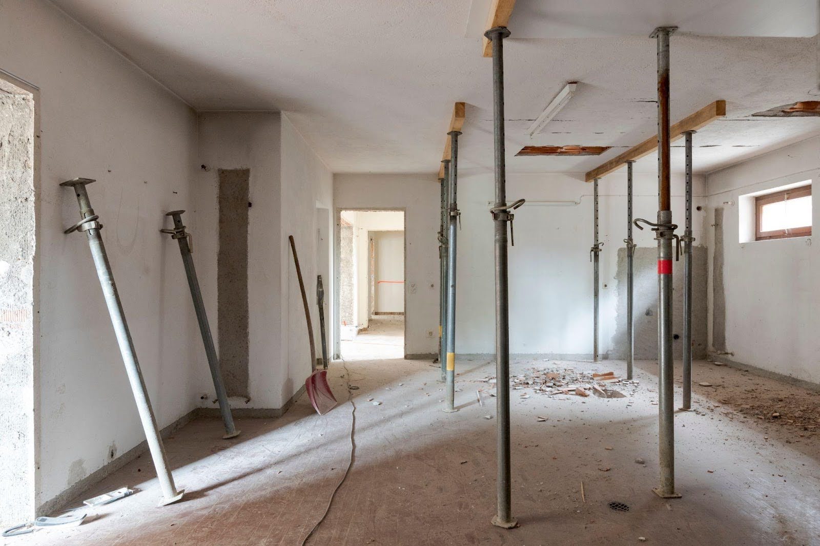 Interior view of a room cluttered with an assortment of construction tools and equipment showcasing an active worksite