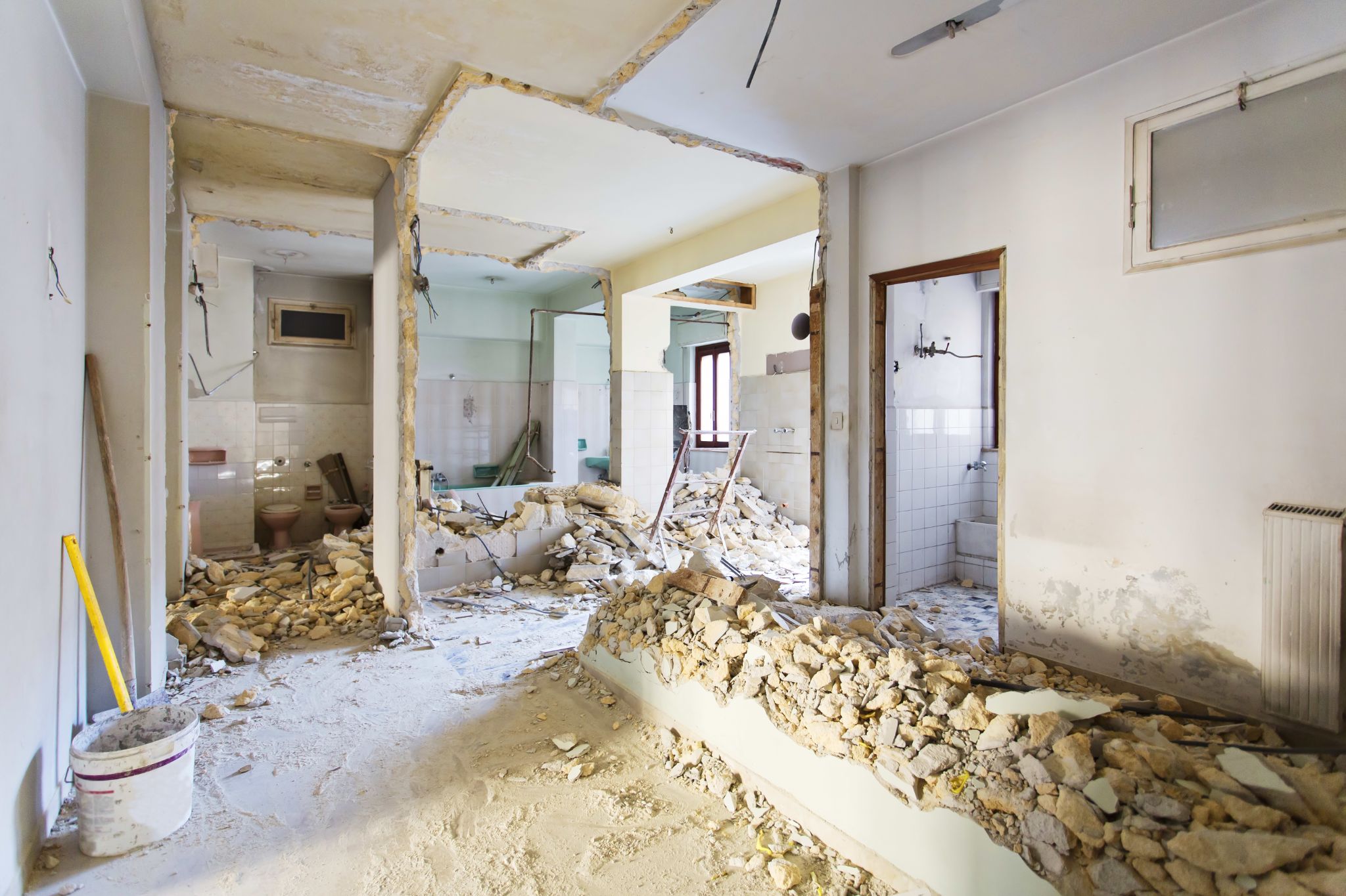 Interior of a building undergoing demolition and renovation with rubble on the floor.